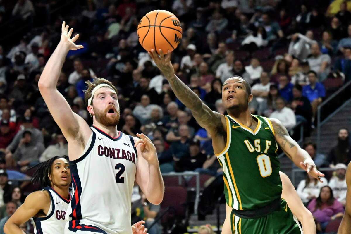San Francisco guard Khalil Shabazz (0) shoots against Gonzaga forward Drew Timme (2) during the first half of an NCAA college basketball game in the semifinals of the West Coast Conference men’s tournament Monday.