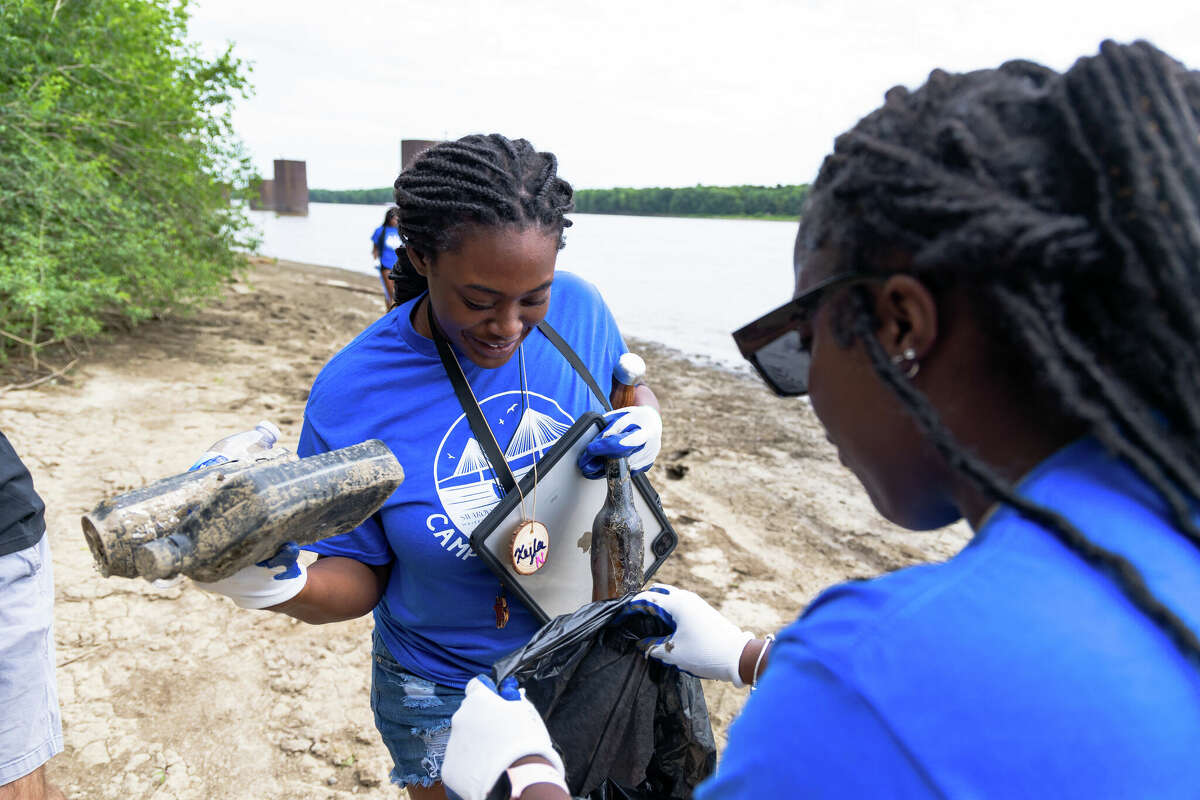 Cahokia High School Student Xyla Nixon cleans up trash along the Mississippi River during Camp Waterschool at the National Great Rivers Research and Education Center.