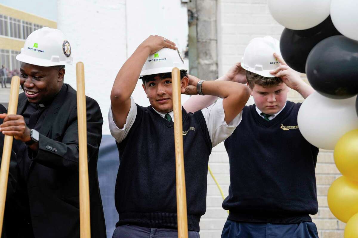 The Rev. Evaristus Chukwu, pastor, St. Peter the Apostle Parish, left, Arturo Alonso, the first accepted student, and Logan Whitley don a hard hats during the opening ceremony and groundbreaking for St. Peter Catholic – A Career and Technical High School on Tuesday, March 7, 2023 in Houston. The Archdiocese of Galveston-Houston will open Houston’s first Catholic career and technical high school in the fall. The school is designed to accommodate up to 200 students during Phase 1 beginning with an incoming freshman class of 50 students. Career pathways for students will first focus on information technology and web development; business, marketing, and finance; architecture and construction; education and training; and other major subjects.