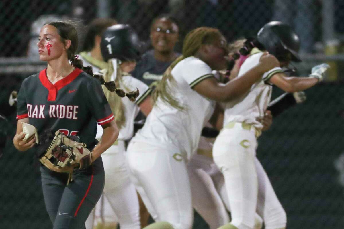 Oak Ridge starting pitcher Savanna Conway walks off the field as Conroe players mob McKenna Griffin after her walk-off, RBI-single in the seventh inning gave the Lady Tigers a 2-1 win during a District 13-6A high school softball game at Conroe High School, Tuesday, March 7, 2023, in Conroe.