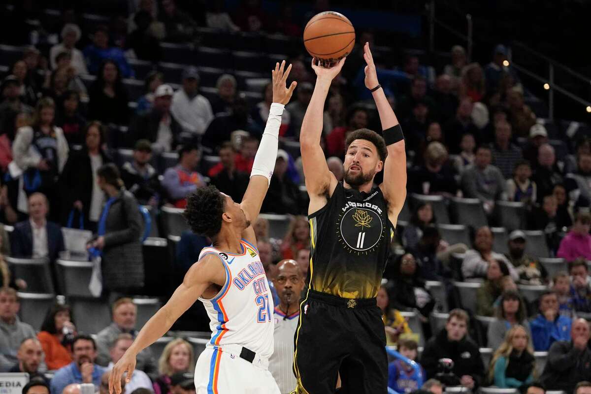 Golden State Warriors guard Klay Thompson (11) shoots over Oklahoma City Thunder guard Aaron Wiggins (21) in the first half of an NBA basketball game Tuesday, March 7, 2023, in Oklahoma City. (AP Photo/Sue Ogrocki)
