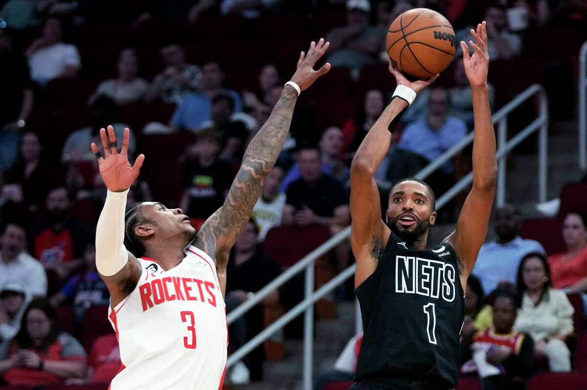 Nets forward Mikal Bridges shoots a 3-pointer as Rockets guard Kevin Porter Jr. defends during the first half of Brooklyn's victory Tuesday at Toyota Center.