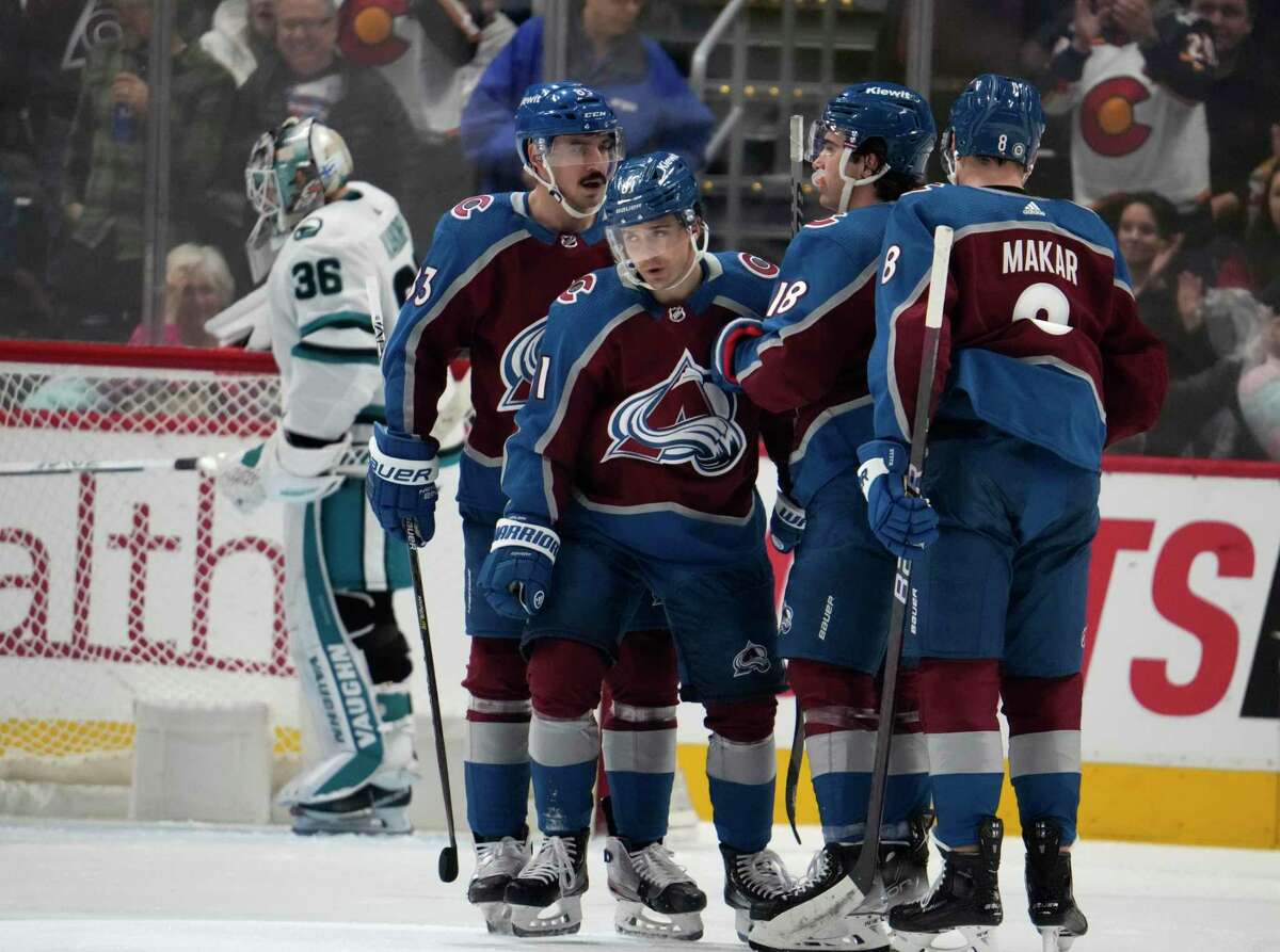 Colorado Avalanche center Denis Malgin, second from left in front, is congratulated after scoring a goal by, from front left, winger Matt Nieto, center Alex Newhook and defenseman Cale Makar as San Jose Sharks goaltender Kaapo Kahkonen reacts in the background in the second period of an NHL hockey game Tuesday, March 7, 2023, in Denver. (AP Photo/David Zalubowski)