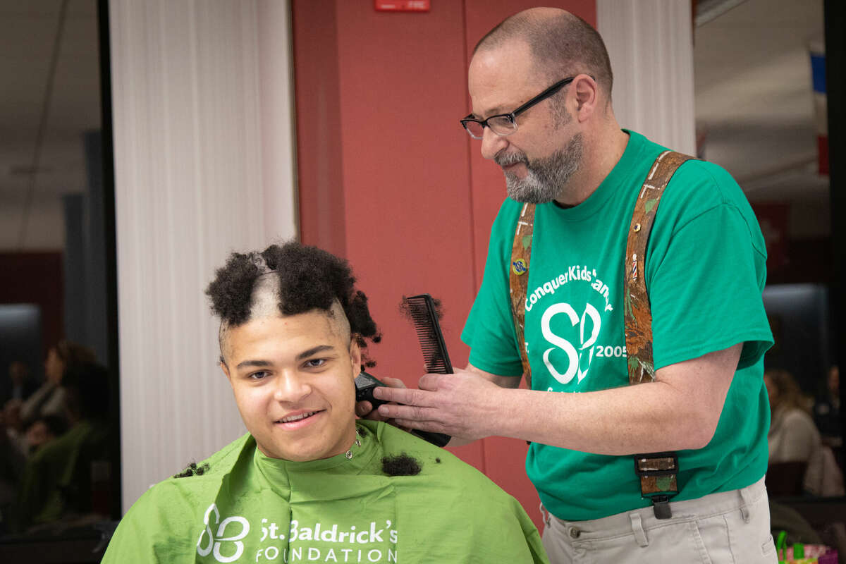 Volunteer cutter Jerry Ventrella of Branchville Hair Design in Wilton goes to work on Jackson Duncan, 17, of Wilton on Tuesday, March 7, at Wilton High School. Funds the student raised for getting his head shaved will benefit the St. Baldrick's Foundation event. It was held in cooperation with the student-organized group Conquer Kids' Cancer.