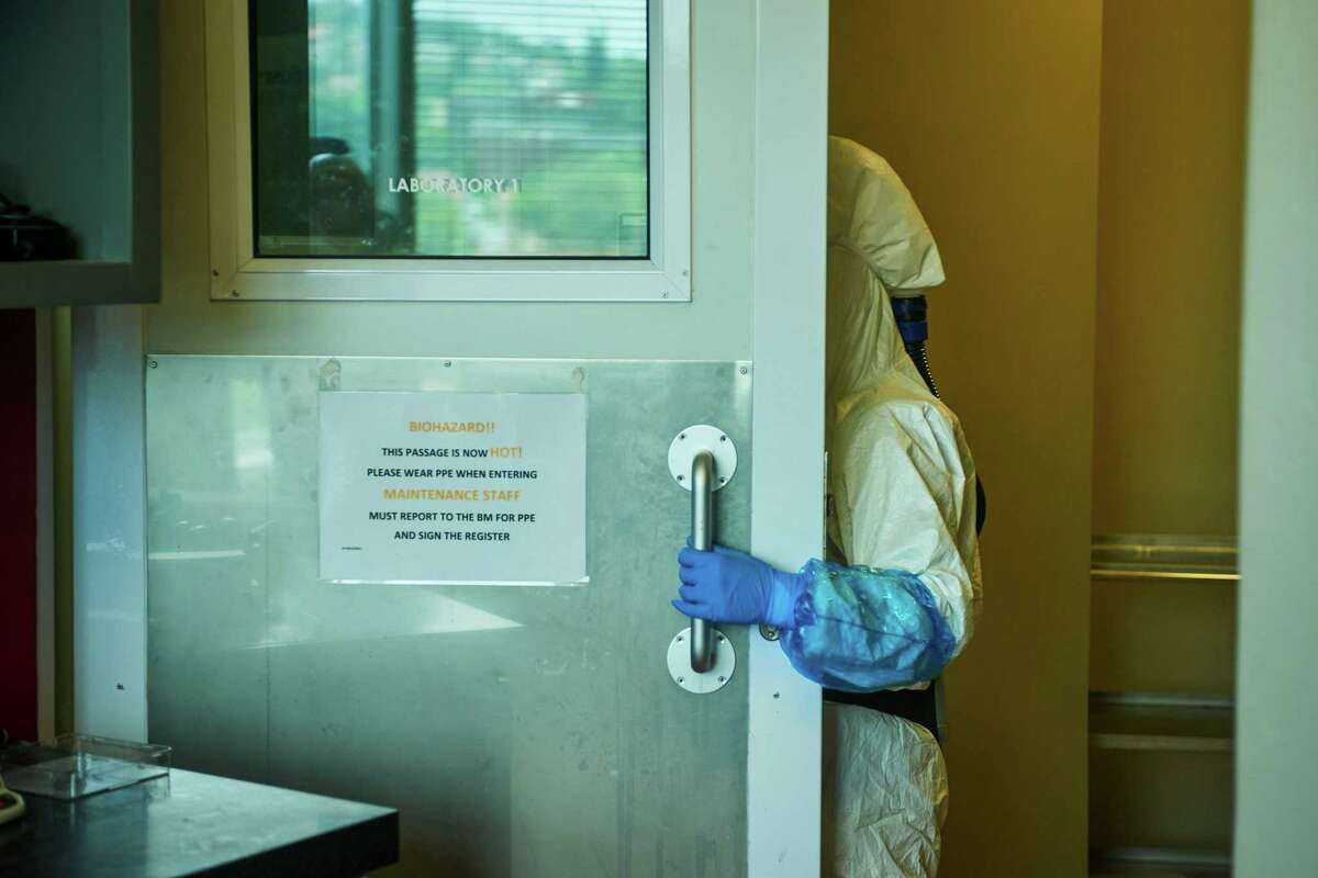 A technician wearing a full body protection suit enters a BSL-3 Covid-19 research laboratory at the African Health Research Institute in Durban, South Africa, in 2021.