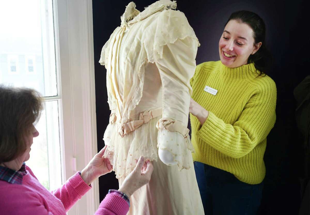 Programs and Collections Director Nicole Carpenter, right, and Kathy Nixon, of Westport, put a 1870's wedding dress on display in the new "I Thee Wed" exhibit of vintage wedding dresses at The Wesport Museum at 25 Avery Place in Westport, Conn. on Wednesday, March 08, 2023. The exhibit opens to the public on Friday, March 10.