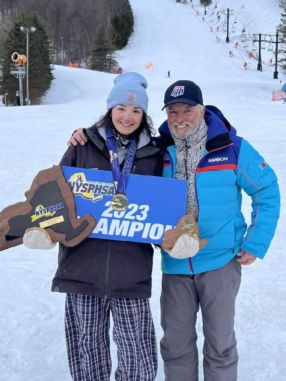 Shenendehowa's Micaela Leonard, left, poses with Shen ski coach Rich Burnley after Leonard won the giant slalom at the 2023 state championships.