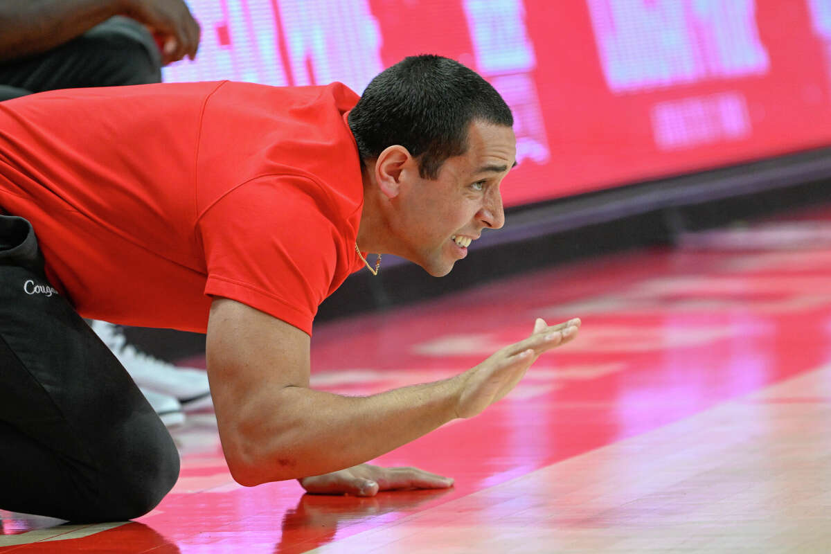 HOUSTON, TX - JANUARY 28: Houston Cougars assistant basketball coach Kellen Sampson slaps the floor as he cheers on the defense during the basketball game between the Cincinnati Bearcats and Houston Cougars at the Fertitta Center on January 28, 2023 in Houston.