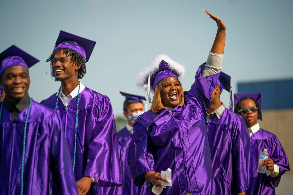 Shantinique Williams waves to the crowd as the processes onto the field for the commencement ceremony for Wheatley High School on Saturday, June 12, 2021, at Barnett Stadium in Houston.