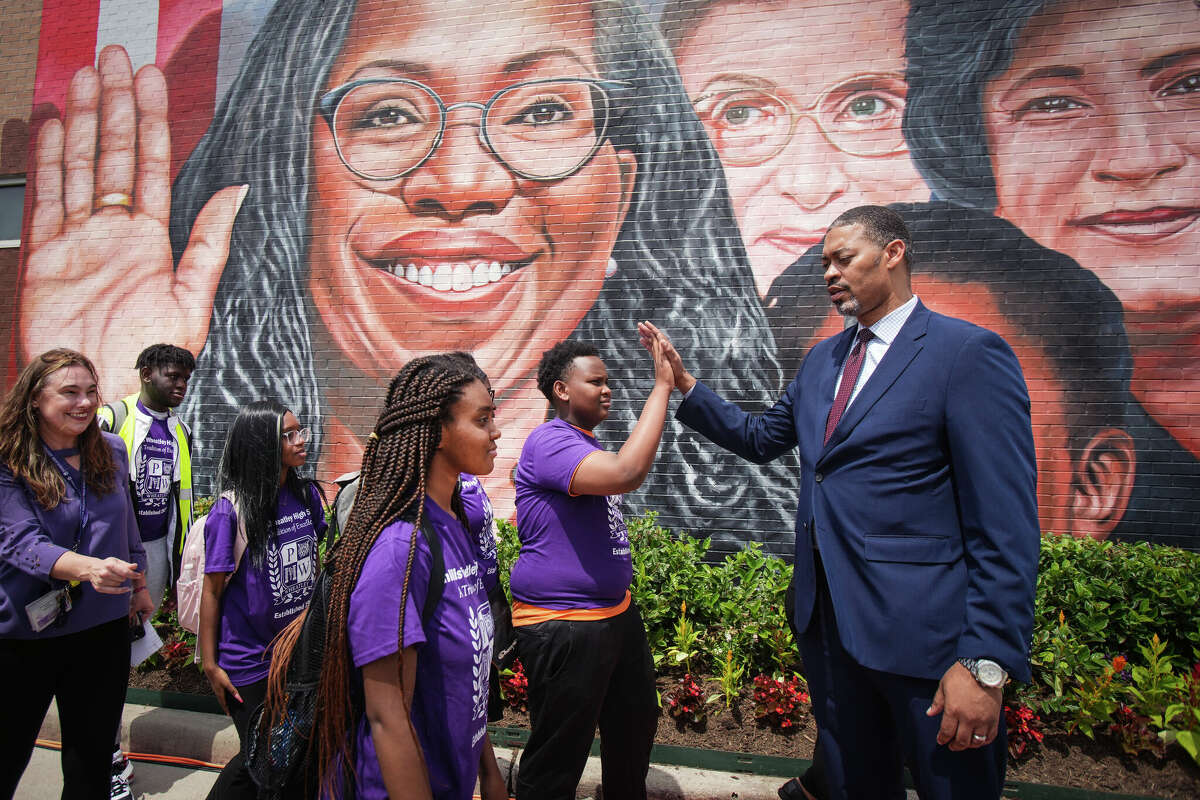 Wheatley High School Principal Joseph Williams high-fives student Abdulhakim Nzeyiamana following an unveiling ceremony of a mural celebrating Supreme Court Justice Ketanji Brown Jackson's confirmation at Finnigan Park in Fifth Ward Wednesday, April 20, 2022 in Houston.