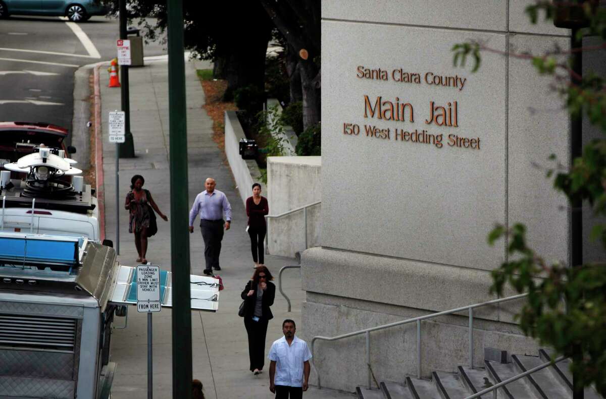 In this photo taken, Wednesday Sept. 2, 2015, pedestrians walk past the Santa Clara County Jail in San Jose, Calif. 
