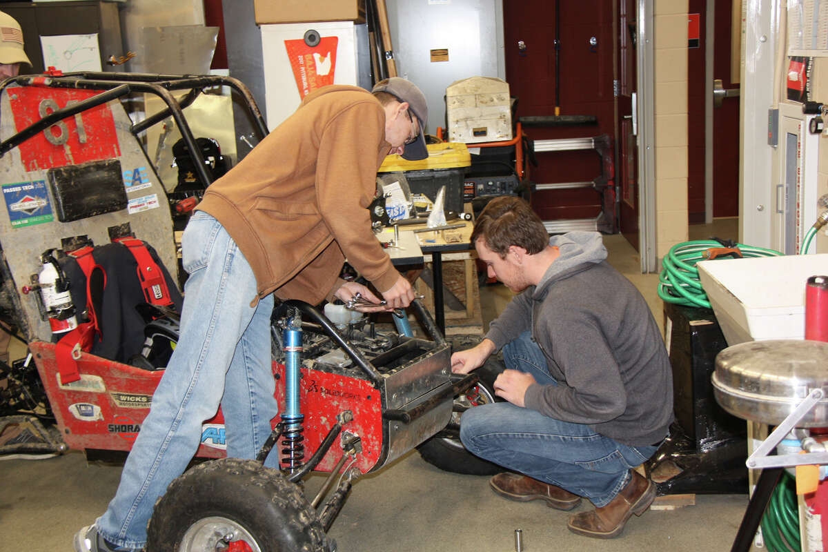 Cougar Baja President Matthew Buchholz, left, helps another team member with a final parts check before taking the baja cars out for some exercise.