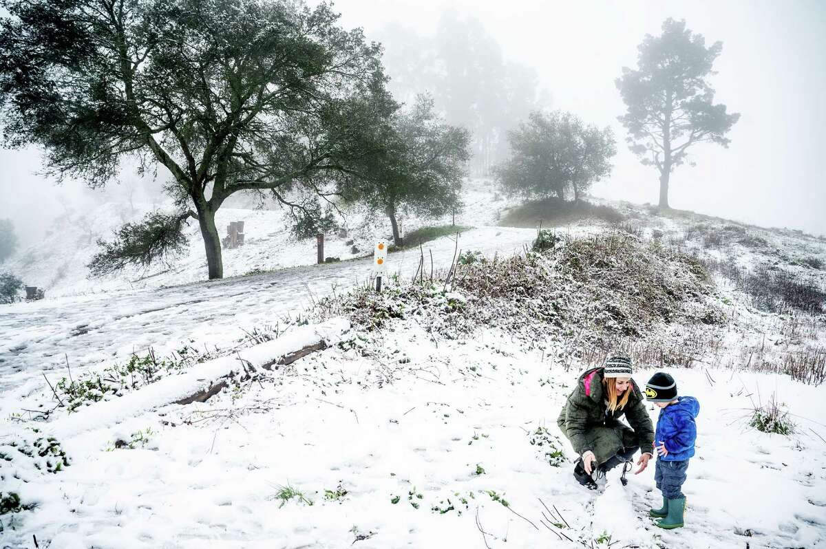 Aggie Tragas and son Loukas, 3, build a snowman in Tilden Park in Berkeley on Feb. 24.