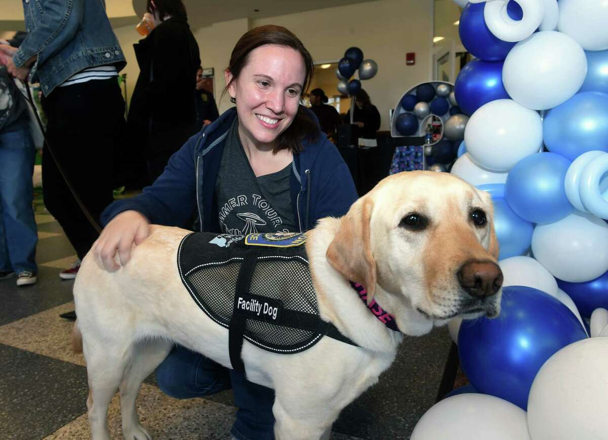 Southern Connecticut State University senior Elizabeth Merkt pets K9 service dog, Chase, during a birthday party for other service dogs at SCSU's Adanti Student Center in New Haven on March 9, 2023.