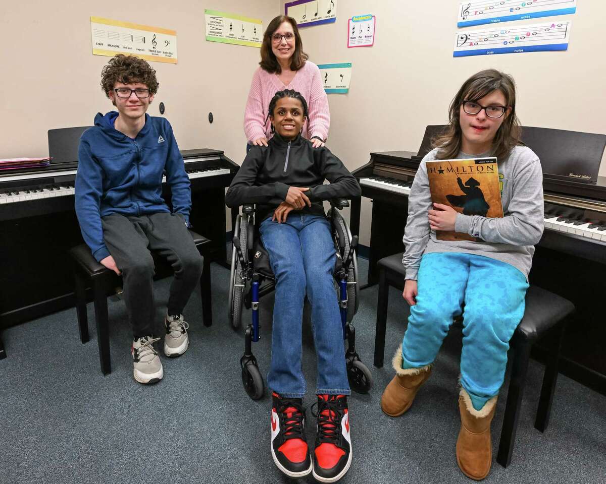 From left seated: Piano students Matthew Preston, Christopher Harrison and Anna Maple at Creative Harmonies Music Studio on Wednesday, March 8, 2023, in Colonie NY. Standing is teacher and studio owner Dee Cucinotta.