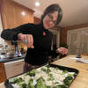 Caroline Barrett seasons pressed tofu and broccoli before roasting in the oven.