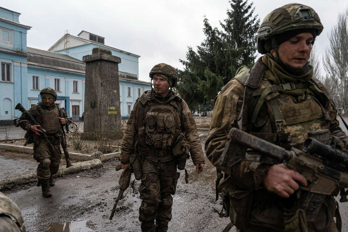 Ukrainian servicemen who recently returned from the trenches of Bakhmut walk on a street in Chasiv Yar, Ukraine, Wednesday, March 8, 2023. (AP Photo/Evgeniy Maloletka)