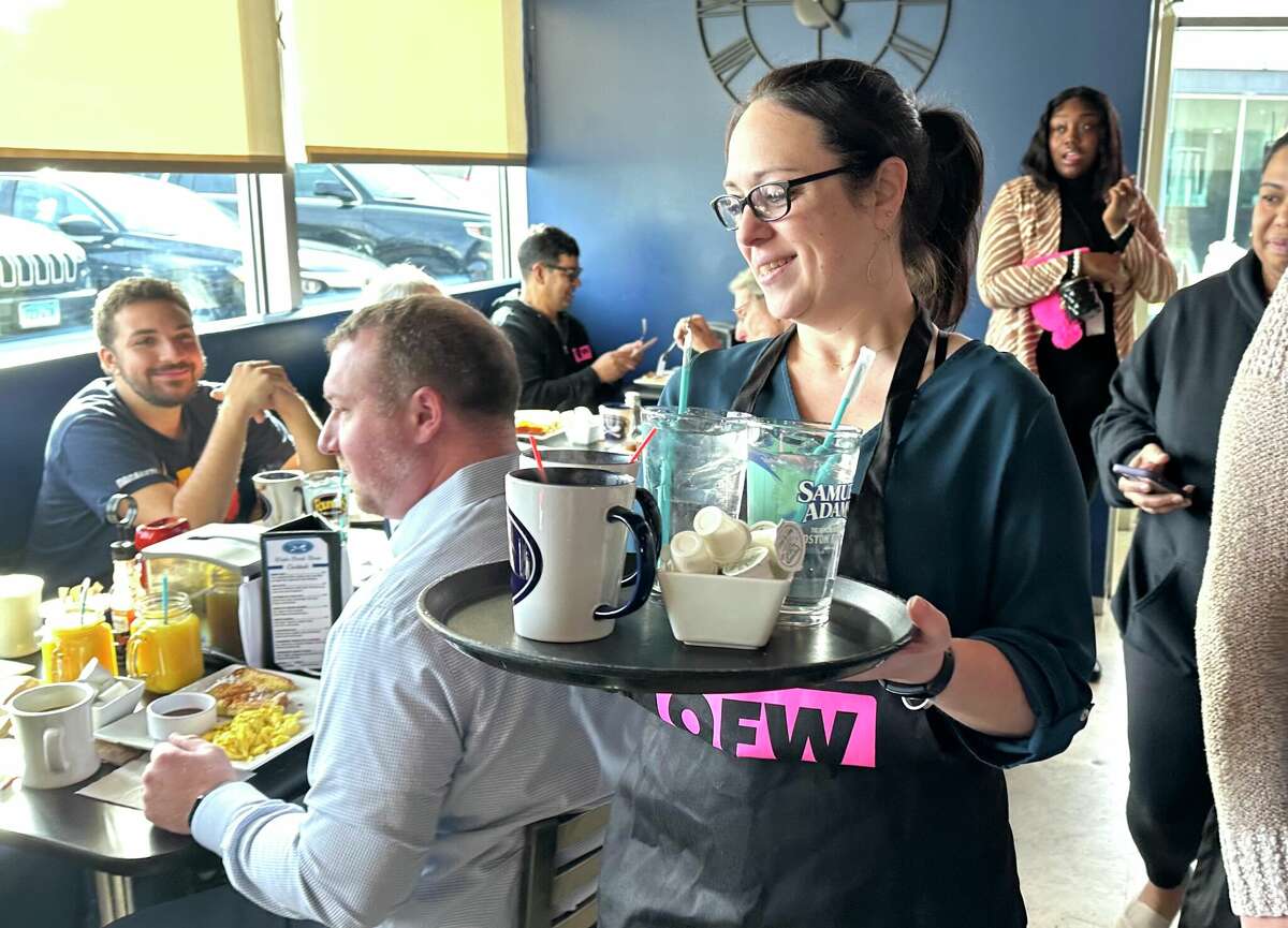 State Rep. Kara Rochelle, D-Ansonia, took a turn waiting tables Friday morning at the Blue Plate Kitchen in West Hartford to call attention to an effort in the legislature to upgrade the $6.38 tipped wage for servers with the full minimum wage as part of the One Fair Wage national campaign. 