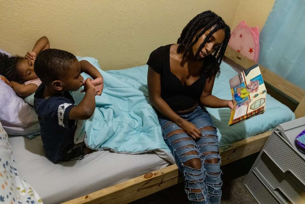 Destiny Williams reads a book to her two older children before bed.