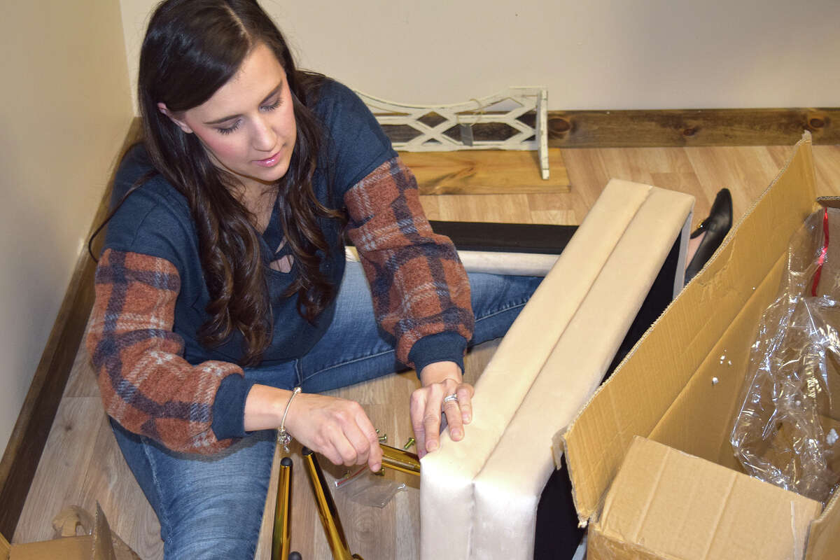 Lauren Tomhave puts the final touches on an item at Rooted Homestead, a home goods store.