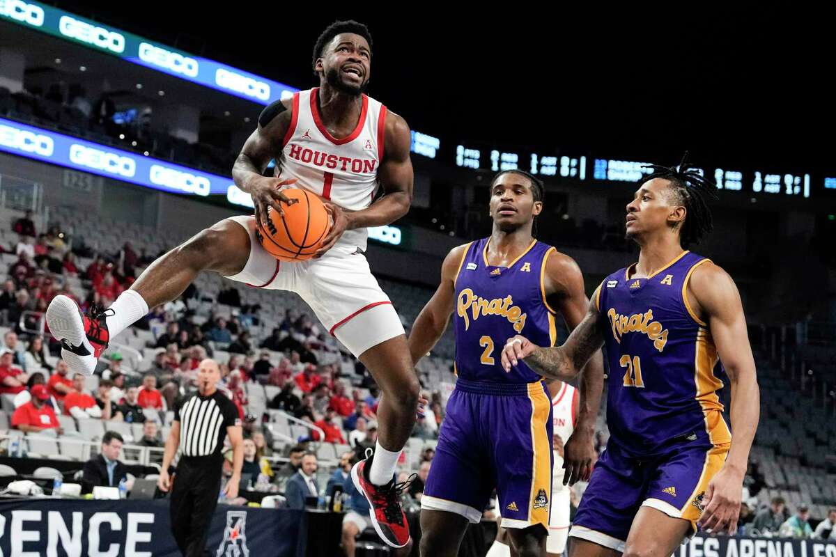 Houston guard Jamal Shead (1) leaps past East Carolina forward Ezra Ausar (2) and guard Jaden Walker (21) as he drives the lane during the first half of a quarterfinal basketball game in the American Athletic Conference men's basketball tournament on Friday, March 10, 2023, in Fort Worth.