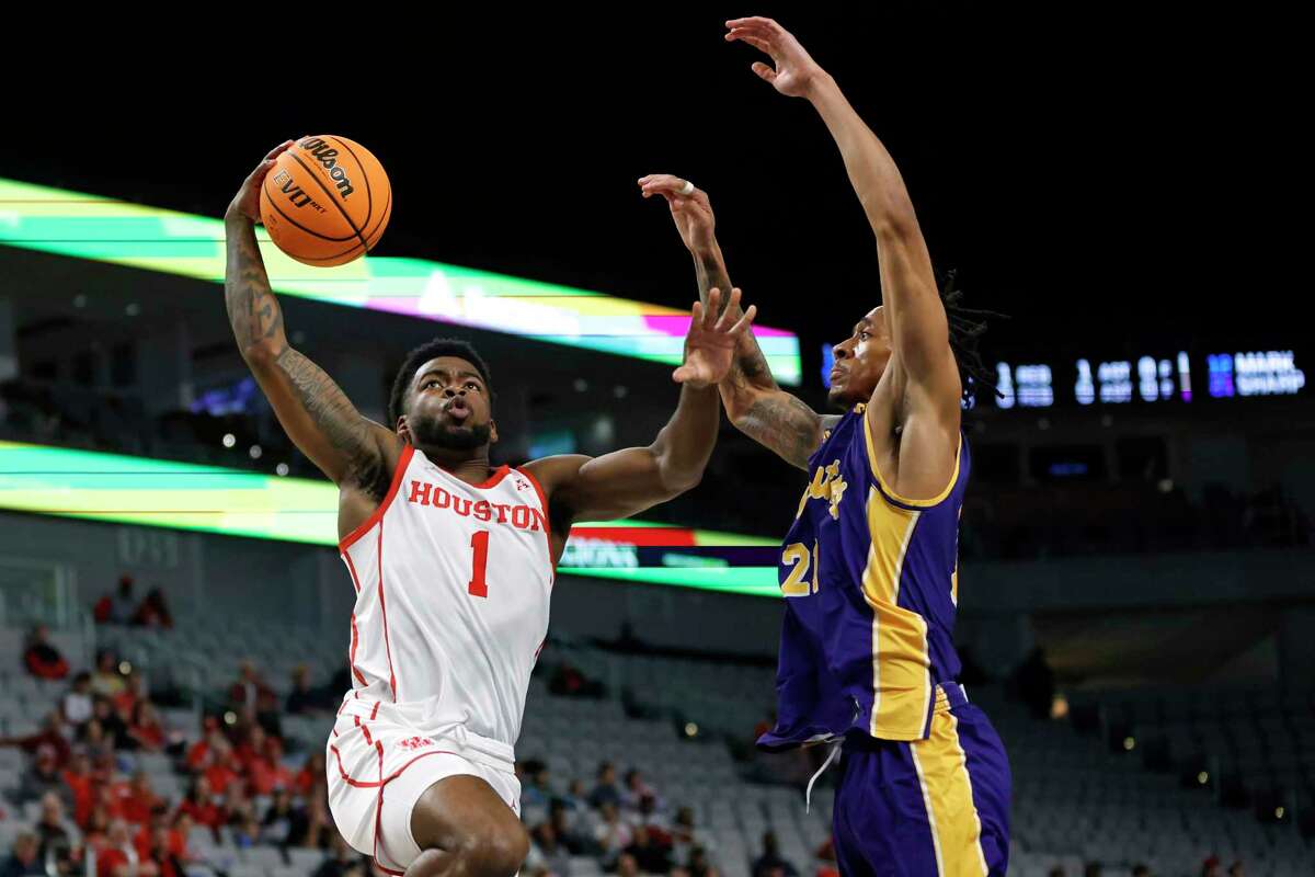 Houston guard Jamal Shead (1) goes to the basket as East Carolina guard Jaden Walker (21) defends during the first half of an NCAA college basketball game in the quarterfinals of the American Athletic Conference Tournament, Friday, March 10, 2023, in Fort Worth, Texas.