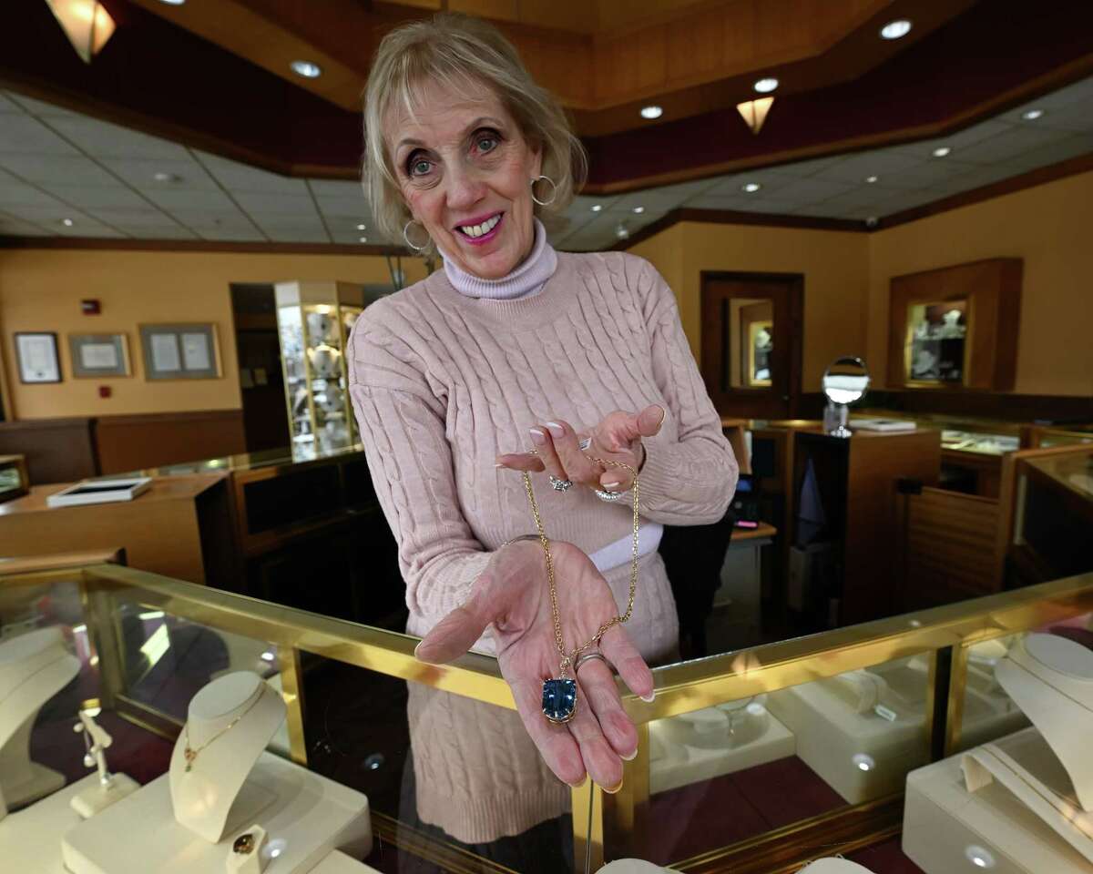 Drue Sanders, the proprietor of Drue Sanders Custom Jewelers, holds a piece of jewelry in her shop on Friday, March 10, 2023, on Western Avenue in Guilderland, NY.
