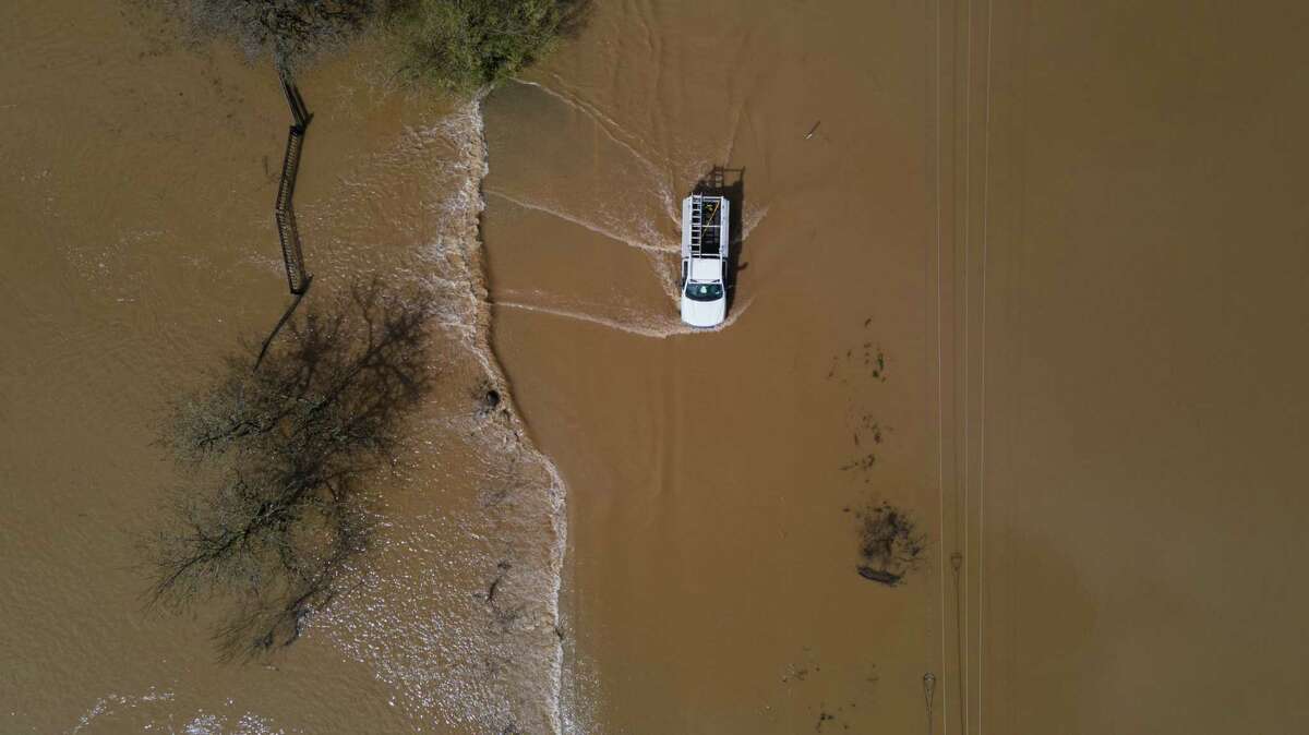 2023年3月10日，星期五，一名司机在加利福尼亚州福里斯特维尔的特伦顿-希尔兹堡路被洪水淹没的路段行驶。整个晚上的大雨给北湾地区带来了洪水。
