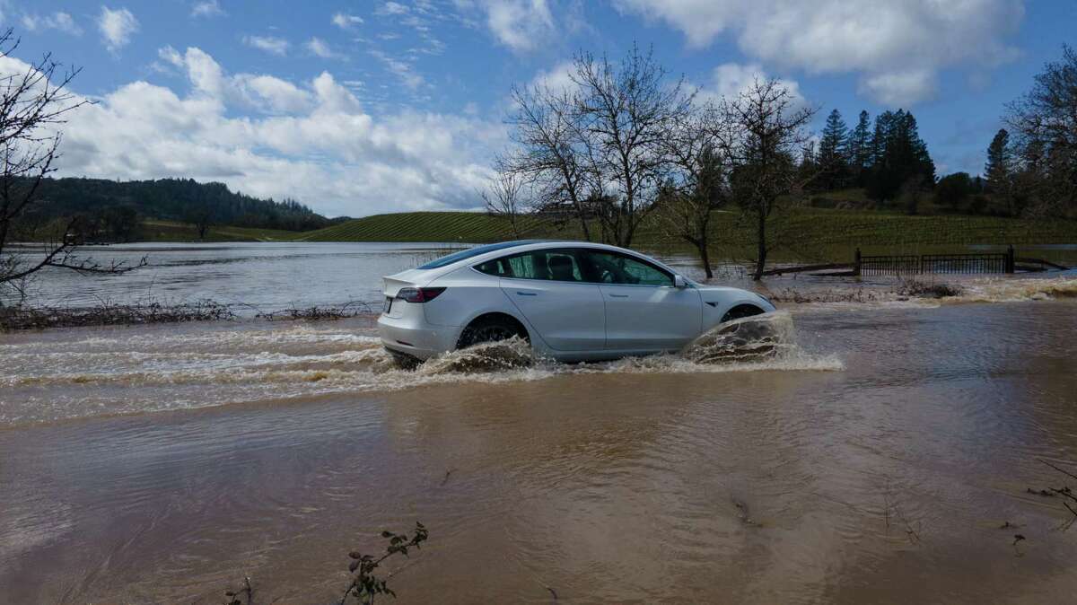一名驾车者开车穿过被洪水淹没的特伦顿-希尔兹堡路。州长加文·纽森签署了一项行政命令，以便更容易地将洪水转移到地下储存。