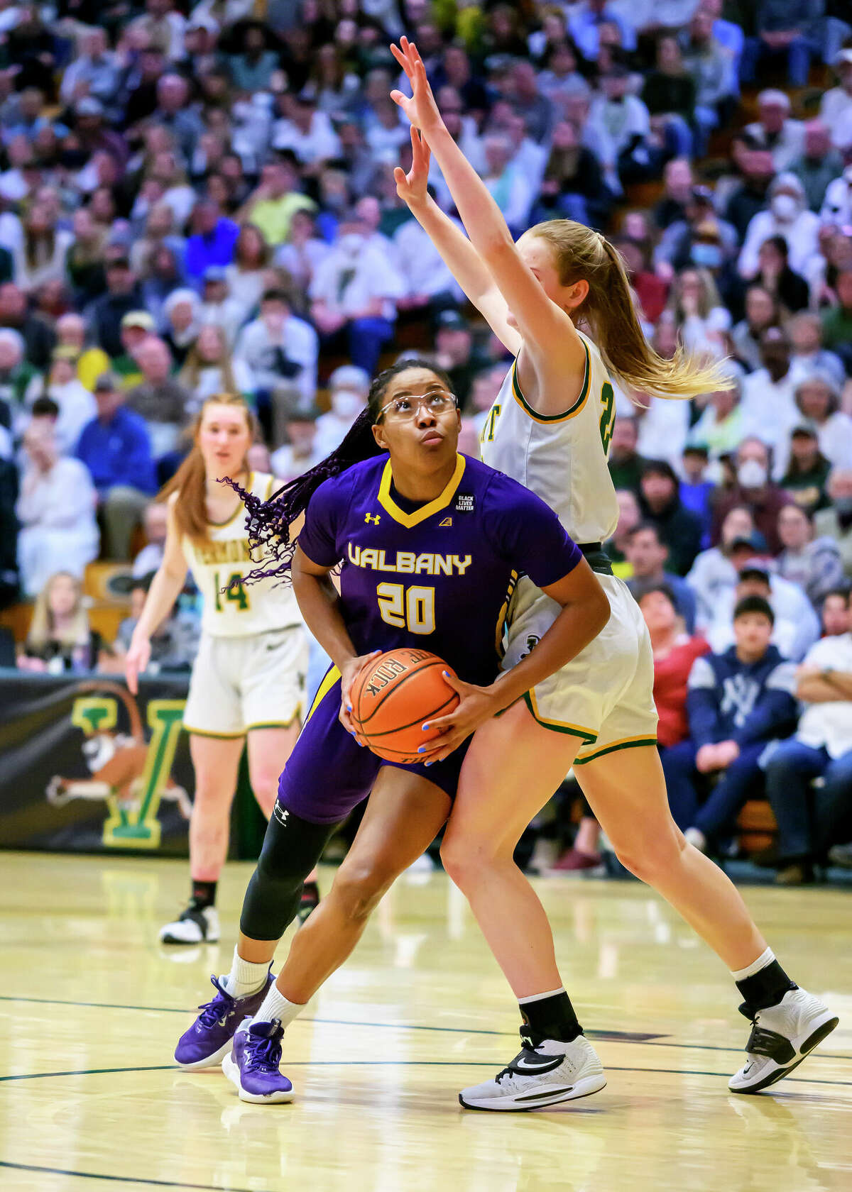 Kayla Cooper, left, of UAlbamy goes to the basket against Vermont in the America East title game Friday, March 10, 2023, at Patrick Gymnasium in Burlington, Vt.