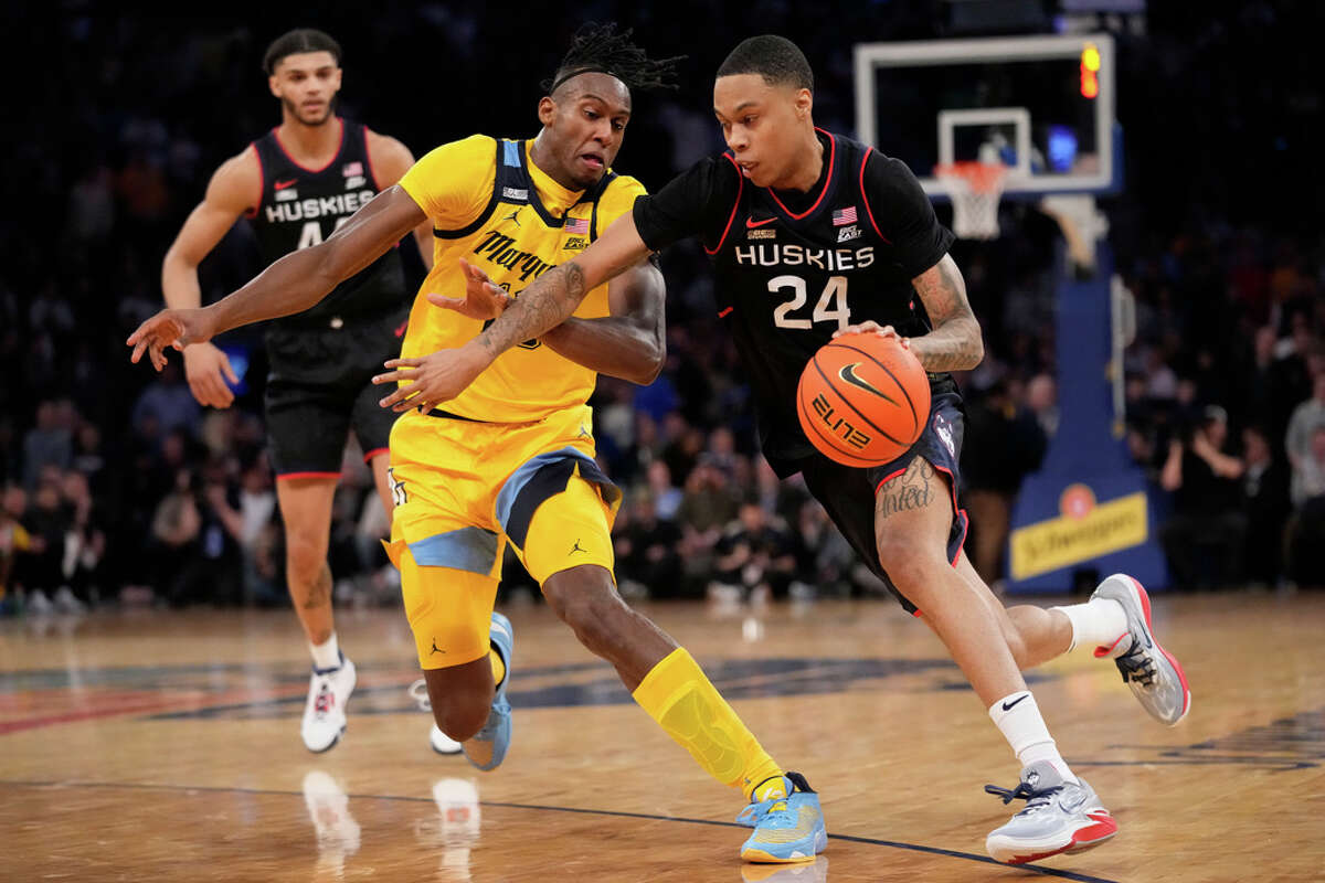 Connecticut's Jordan Hawkins (24) drives against Marquette's Olivier-Maxence Prosper, left, in the second half of an NCAA college basketball game during the semifinals of the Big East conference tournament, Friday, March 10, 2023, in New York. (AP Photo/John Minchillo)