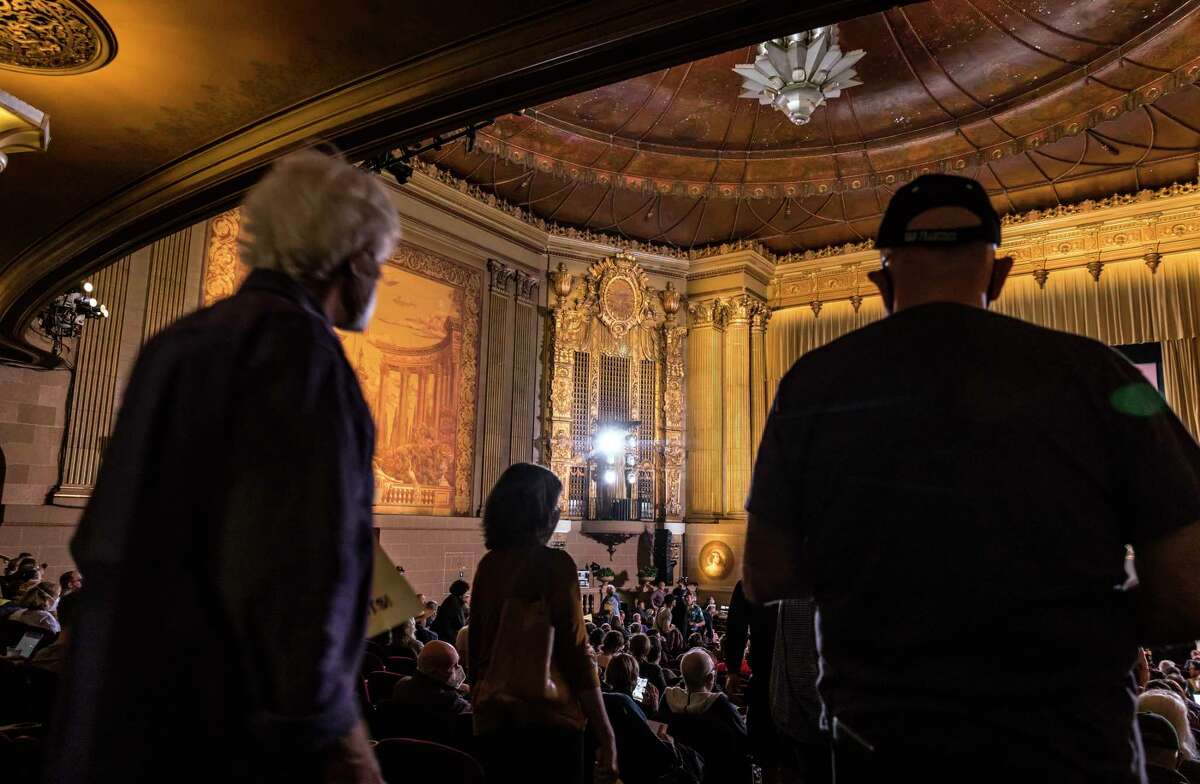 观众们在卡斯特罗剧院参观，然后在8月举行的社区会议上讨论如何挽救这家长期存在的社区电影院的座位。