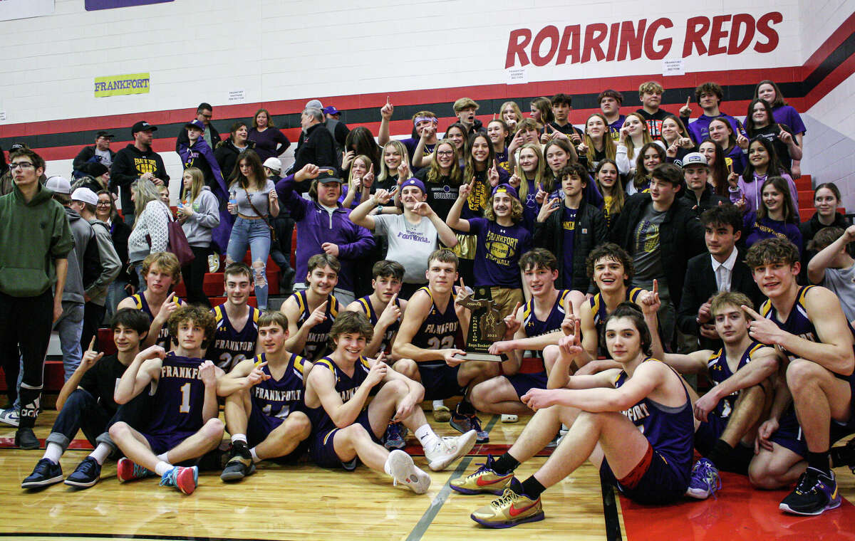 The Frankfort boys basketball team poses for a photo with its district championship trophy and student section on March 10, 2023 at Bear Lake High School. The Panthers defeated Onekama 58-45 to claim their third-straight district title. 