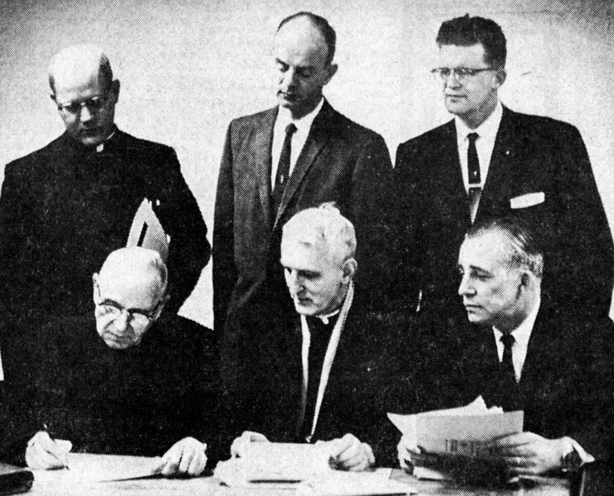 About 27 bids, including seven from general contractors, were opened and tabulated at the St. Joseph Church basement for the construction of the Manistee Catholic Central High School. The tabulation took place on March 14, 1963. Shown (from left, sitting) are Father B.B. Roguszka, pastor of St. Joseph's Church; Father Edward Kubiak, pastor of Guardian Angels Church; and Dick Greenlass, associate architect with Gordon Cornwell. (Standing) are Father Thomas Skuzinski, assistant at St. Joseph's; Alvin Janowiak, president of the MCC school board and Walter Fischer, the MCC fund drive chair. The photo was published in the News Advocate on March 15, 1963.
