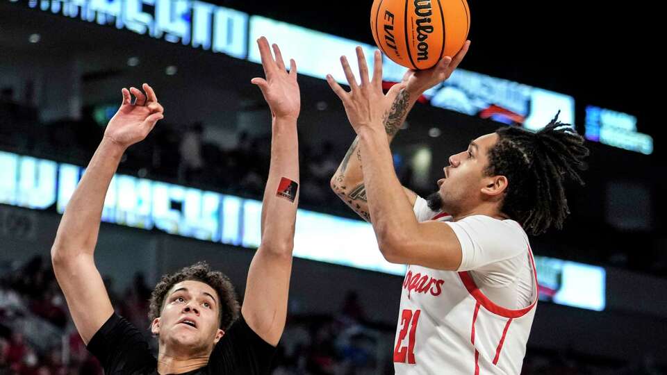 Houston guard Emanuel Sharp (21) takes a shot against Cincinnati guard Dan Skillings Jr. (0) during the second half of a semifinal basketball game in the American Athletic Conference men's basketball tournament on Saturday, March 11, 2023, in Fort Worth.