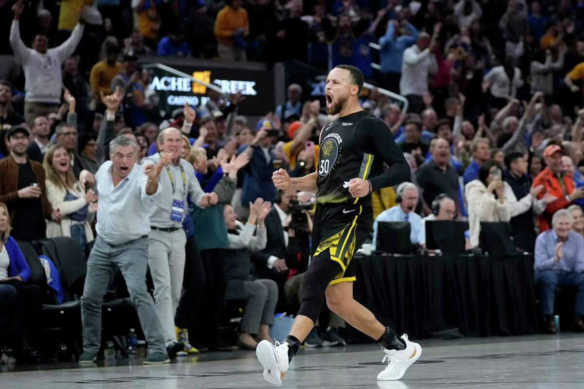 Warriors guard Stephen Curry celebrates after making a 3-pointer in the second half of Golden State's overtime win over Milwaukee at Chase Center on Saturday.