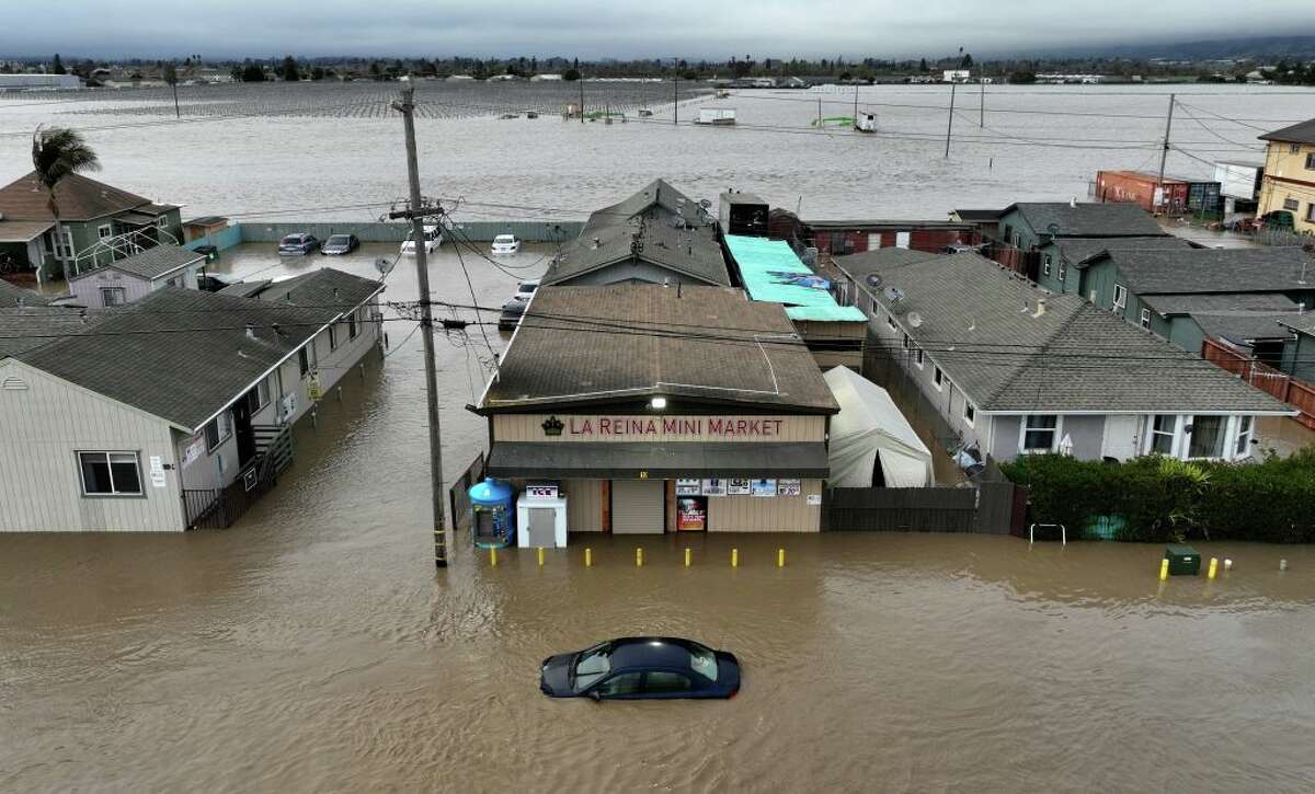 This aerial photograph shows a car and market shop in floodwaters in Pajaro, Calif., on Saturday.