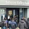 一个工人,中间,告诉客户,硅谷银行总部周五关闭,2023年3月10日在加州圣克拉拉的。硅谷银行被加州监管者和关闭周五早上在美国联邦存款保险公司的控制权。