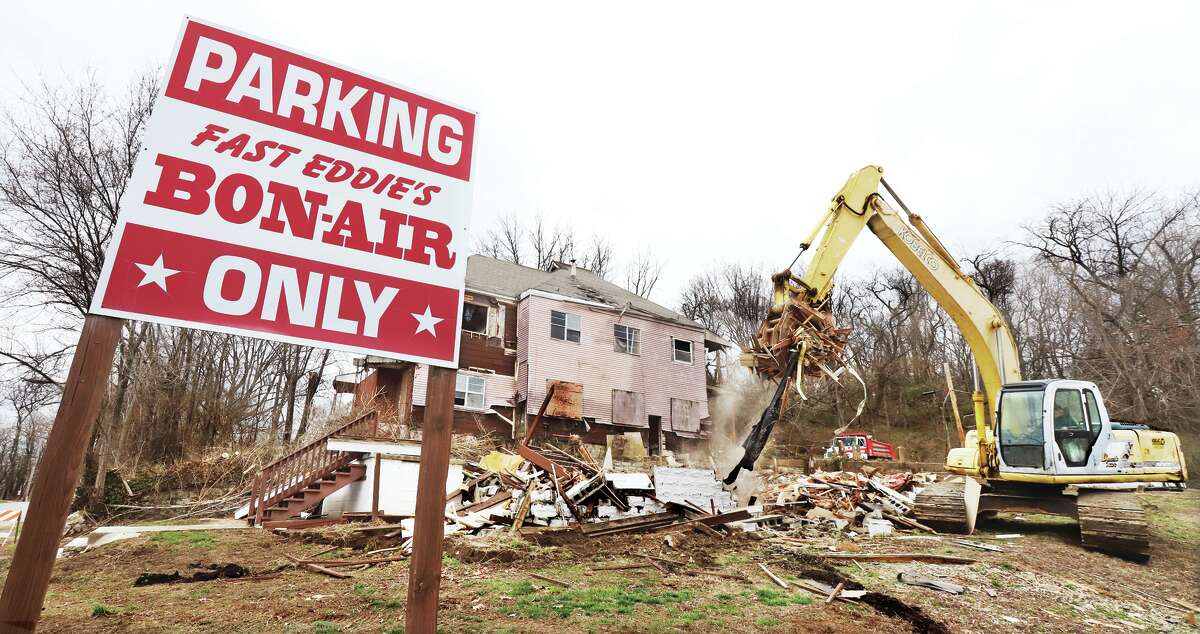 Two derelict houses in the 1400 block of East 4th Street in Alton are coming down to make way for more parking at Fast Eddie's Bon Air. The business had owned the smaller house and bought the larger home, which had been used by homeless people, from the city.