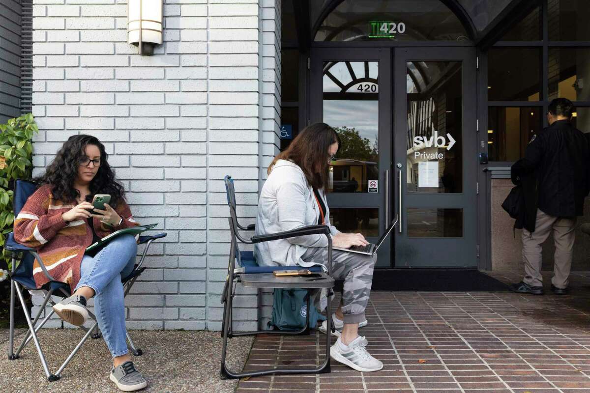 Jessika Harville, left, and Michele Barry wait for the Silicon Valley Bank to open located in Palo Alto, Calif., on Monday, March 13, 2023. The federal government intervened Sunday to secure funds for depositors to withdraw from Silicon Valley Bank after the banks collapse. Barry and Harville were waiting in line to withdraw funds.