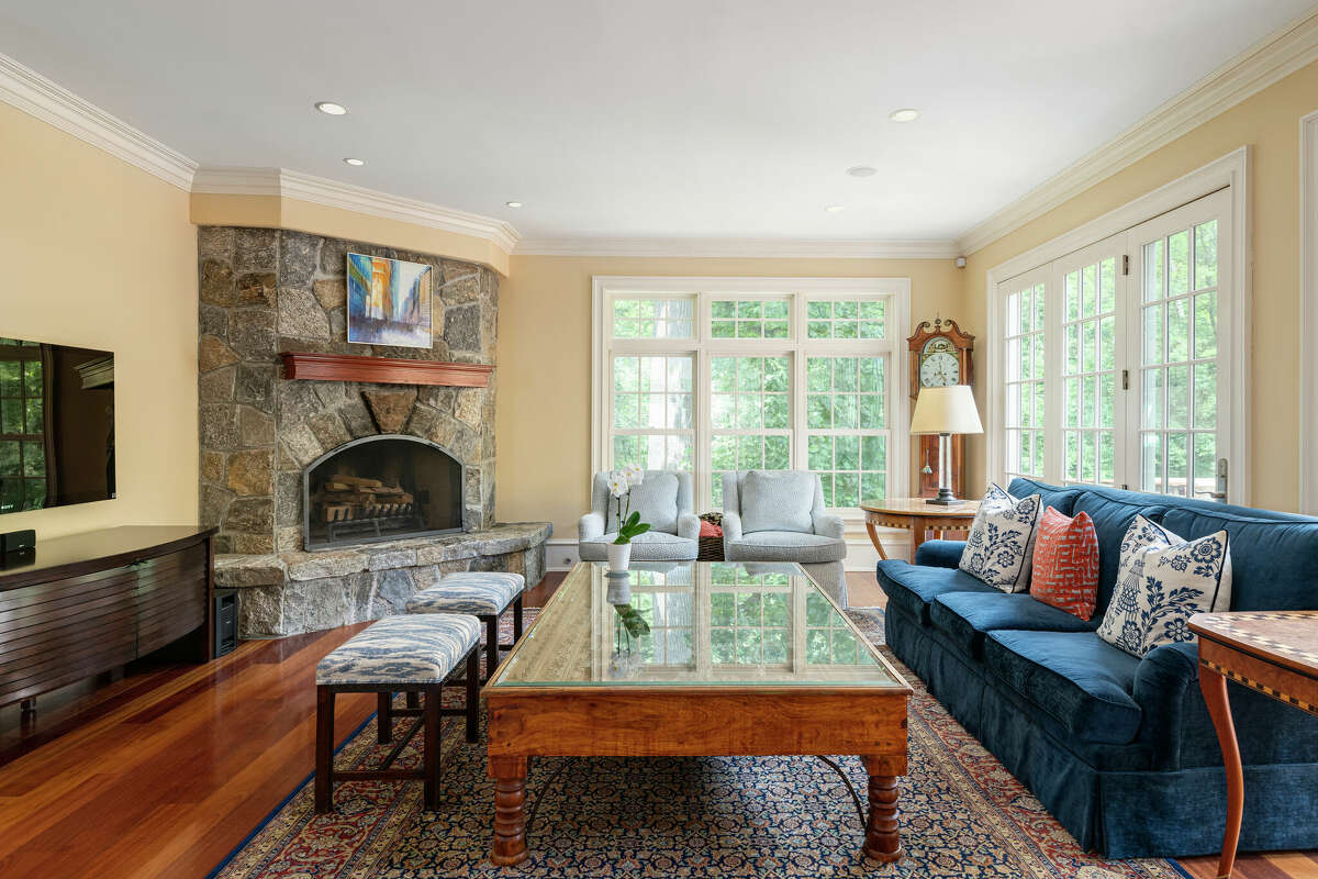 The home’s kitchen opens to both a breakfast room and this family room, made extra cozy by the stone fireplace.