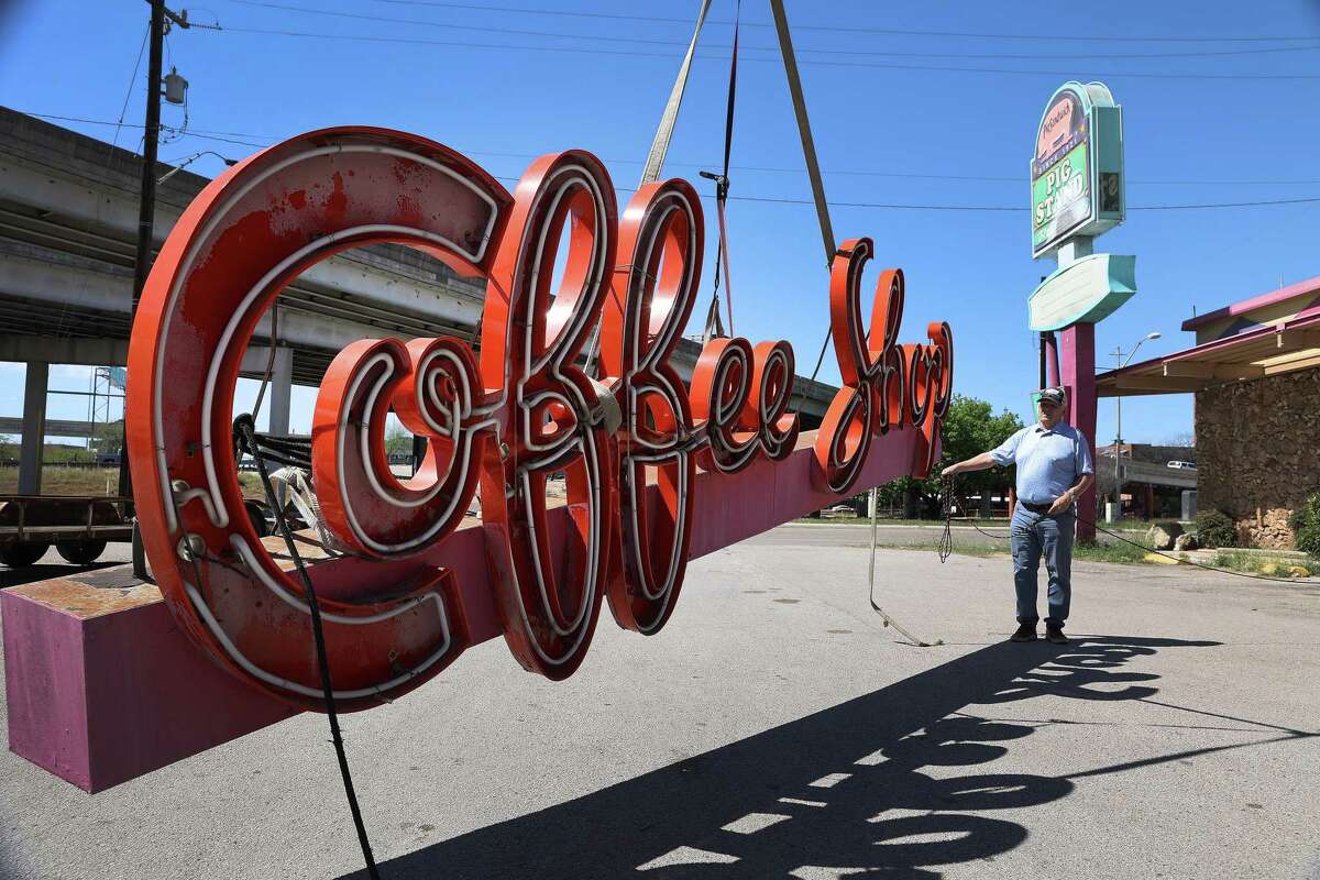 Vintage sign collector Clifton Jones of Austin gets a close up view of the Pig Stand’s “Coffee Shop” neon sign after it gets removed from the building on Monday. Mike Ryan of Texas Neon & LED Sign Co. carefully removed it from the building to add to Clifton’s collection after the iconic business closed Sunday.