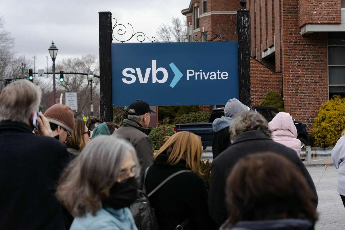 Customers wait in line outside of a Silicon Valley Bank branch in Wellesley, Massachusetts, US, on Monday. The collapse of Silicon Valley Bank has prompted a global reckoning at venture capital and private equity firms, which found themselves suddenly exposed all together to the tech industry's money machine. Photographer: Sophie Park/Bloomberg