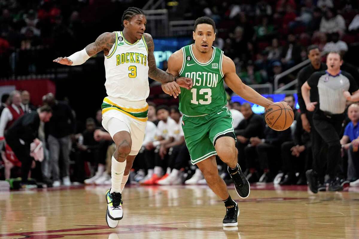 Boston Celtics' Malcolm Brogdon (13) brings the ball up the court as Houston Rockets' Kevin Porter Jr. (3) defends during the first half of an NBA basketball game Monday, March 13, 2023, in Houston.