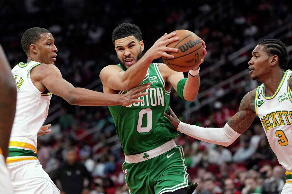 Boston Celtics' Jayson Tatum (0) drives to the basket as Houston Rockets' Kevin Porter Jr. (3) an d Jabari Smith Jr. defend during the first half of an NBA basketball game Monday, March 13, 2023, in Houston.