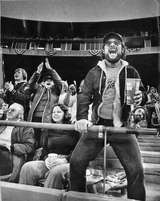 Giants fan Leo Sperandeo Jr. stands holding a beer and cheering in front of other cheering fans during a 1981 game at Candlestick Park.