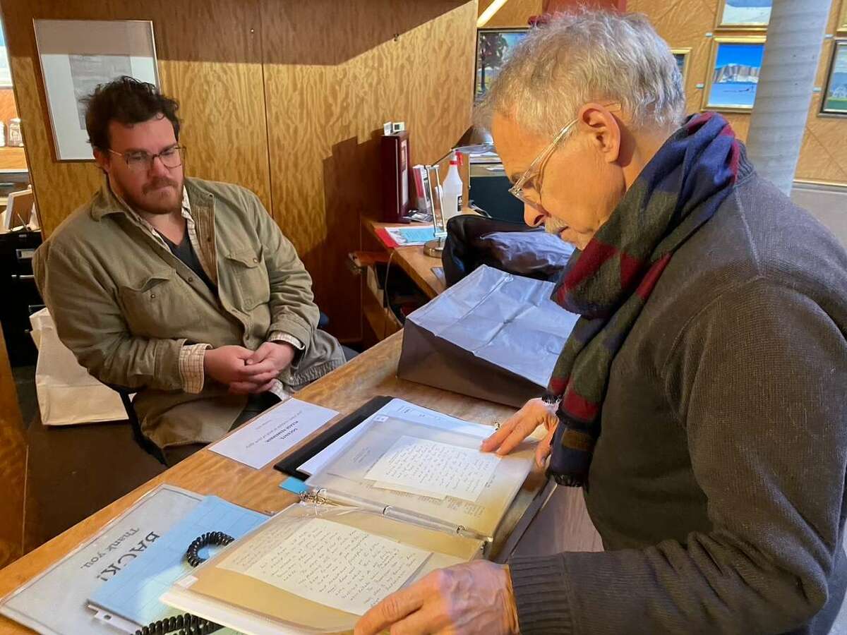 Walter Early, museum preparator for the Plattsburgh State Art Museum and Rockwell Kent scholar Scott Ferris examine documents from the Kent collection.