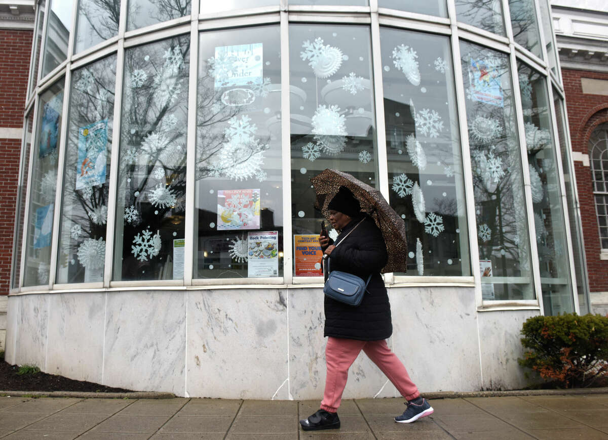 Stamford's Marcia Lewison uses an umbrella to take cover from the light freezing rain falling outside Ferguson Library in Stamford, Conn., Tuesday, March 7, 2023. The area was hit with a minor storm Tuesday that produced minimal accumulations of rain and snow.