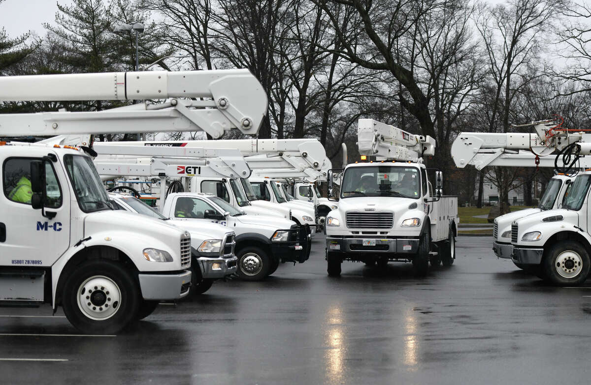 Dozens of cherry picker trucks wait to be dispatched for power line repairs at Scalzi Park in Stamford, Conn., Tuesday, March 7, 2023. The area was hit with a minor storm Tuesday that produced minimal accumulations of rain and snow.