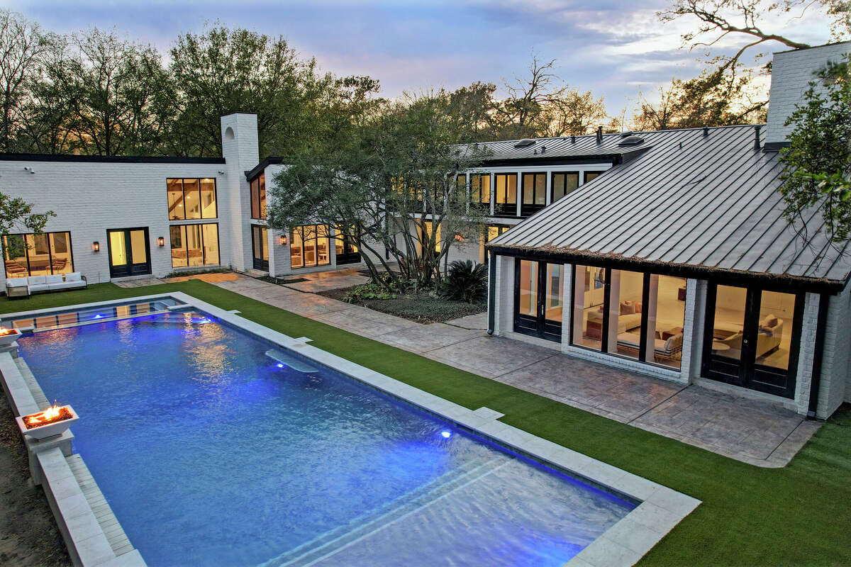 The backyard view of 8 E Rivercrest shows a large resort-style pool.
